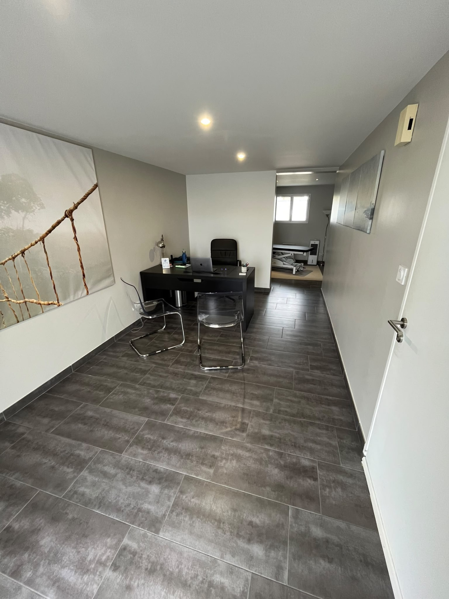 Espace d’accueil du cabinet d’ostéopathie des Clouzeaux avec bureau et rangements